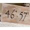 A personalized location sign. The lettering is wood-burned onto reclaimed wood by hand. The sign is finished with a whitewash. 